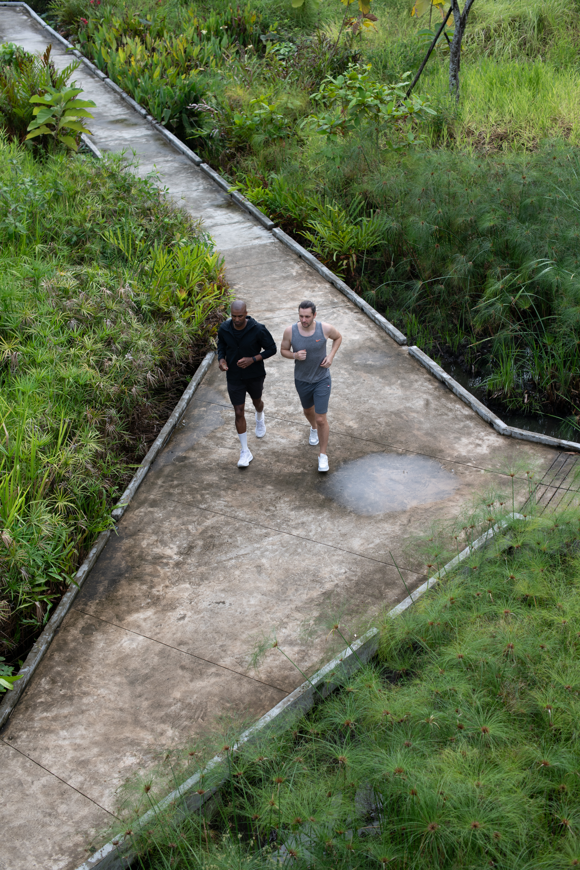 Jonathan running alongside a client on a garden path