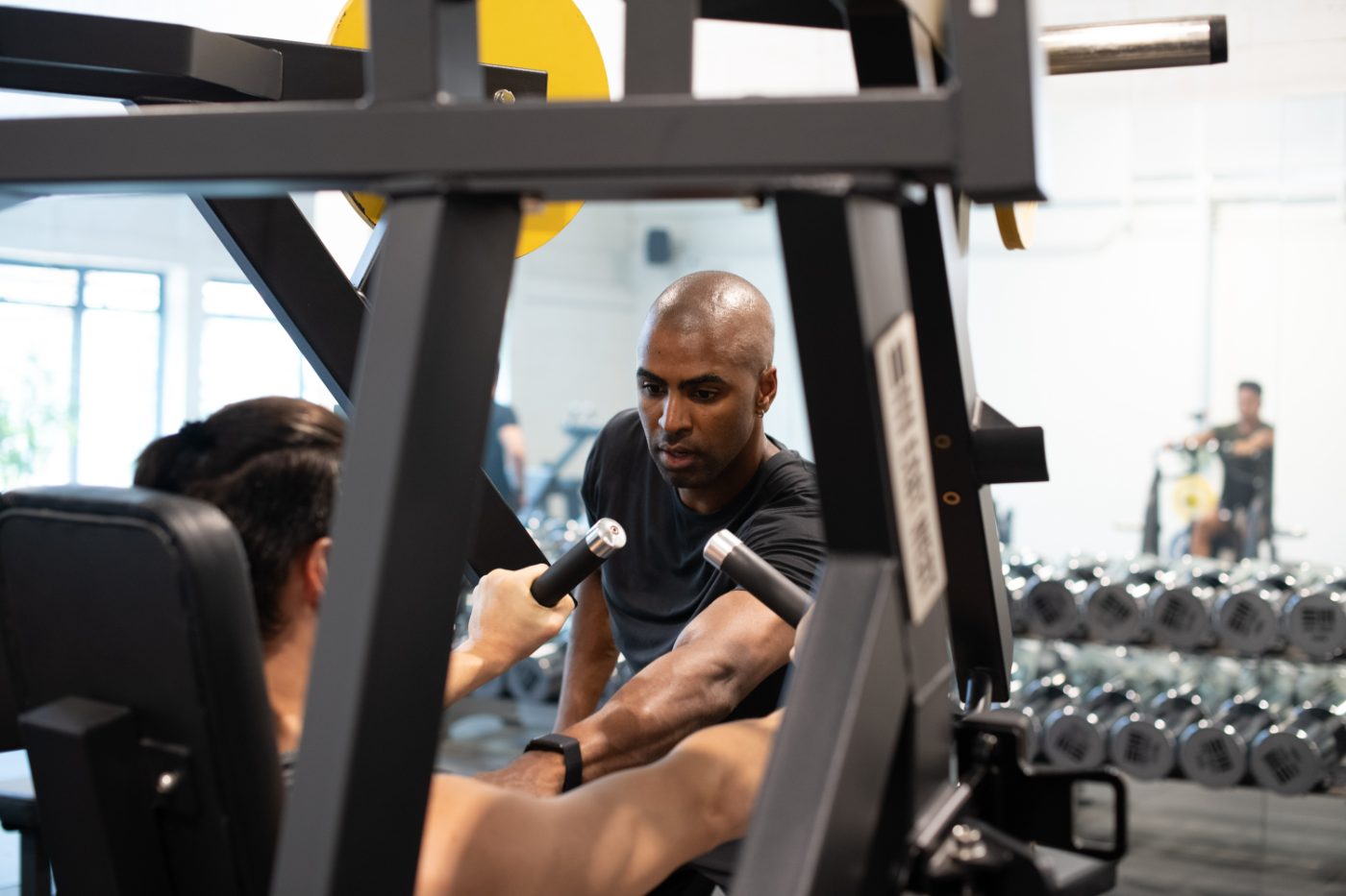 New York City personal trainer spotting a client on a chest press